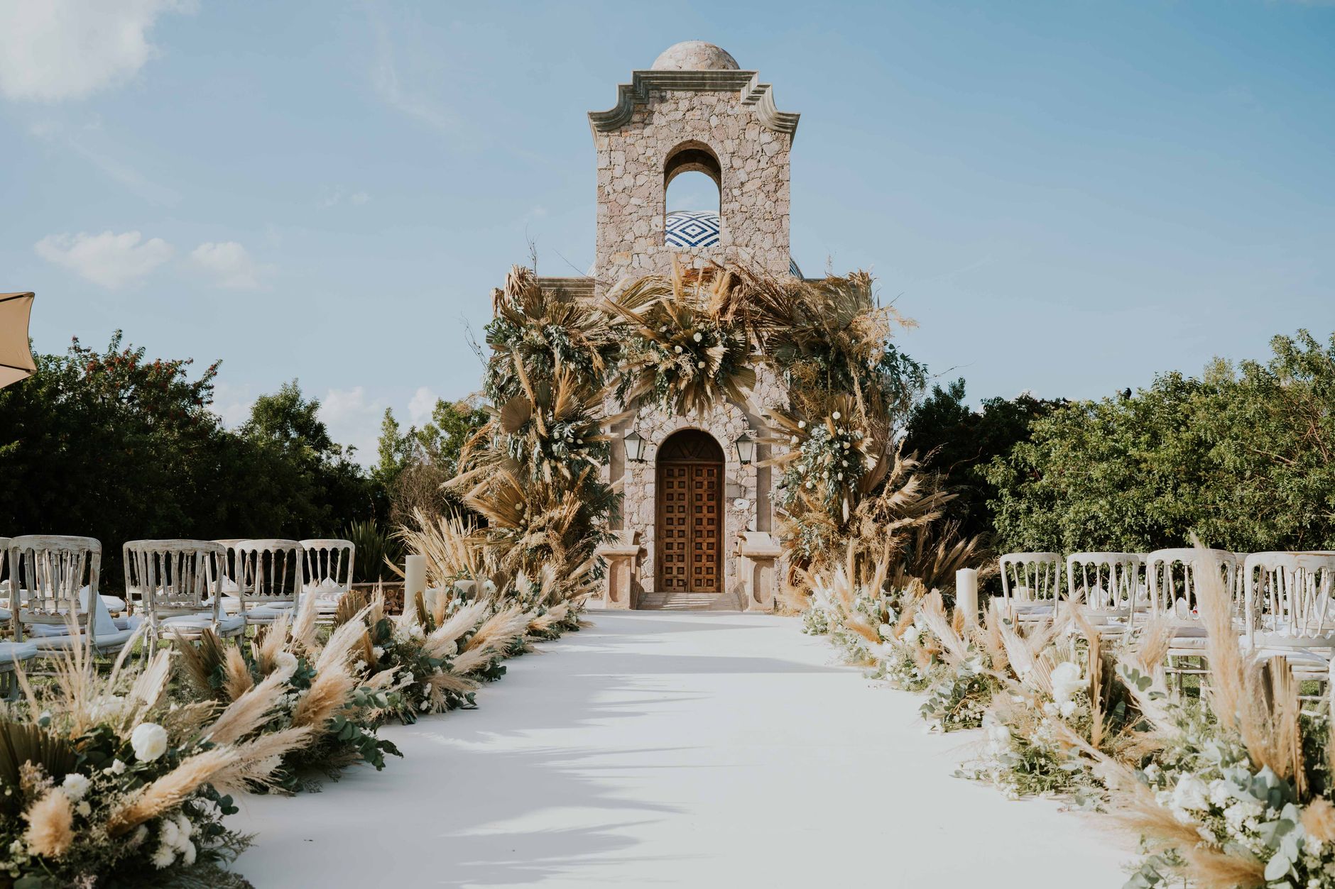Ceremonia de boda de destino al aire libre con arco floral frente al mar